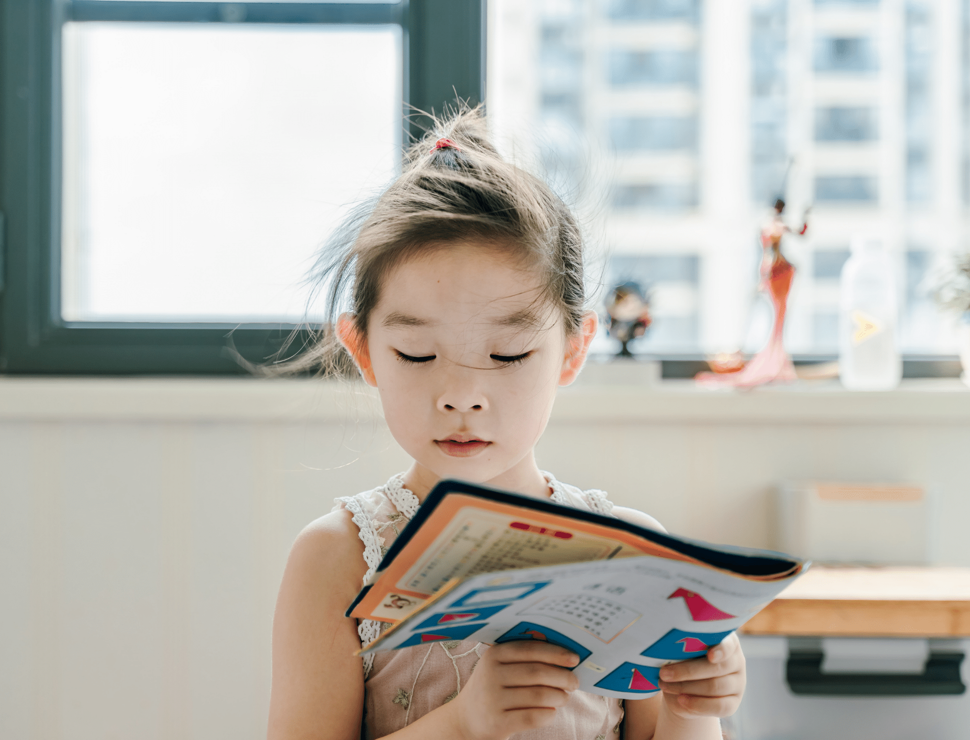 Girl reads a book surrounded by sunlight. Explore alternatives to The Colors of Us children’s book from Britt Hawthorne. Photo: Jerry Wang