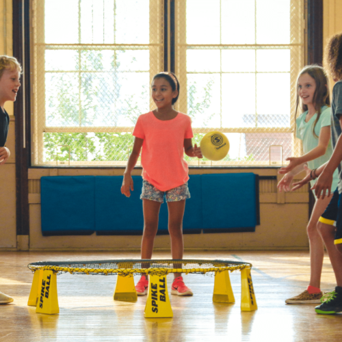 Four kids playing spike ball in a gym. Here's how to address kids when they say that's racist!