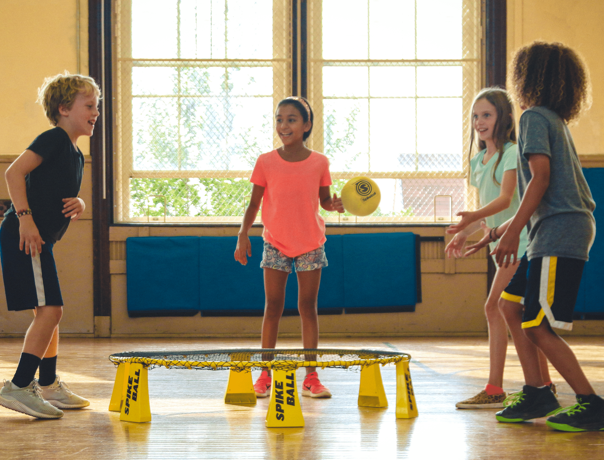 Four kids playing spike ball in a gym. Here's how to address kids when they say that's racist!