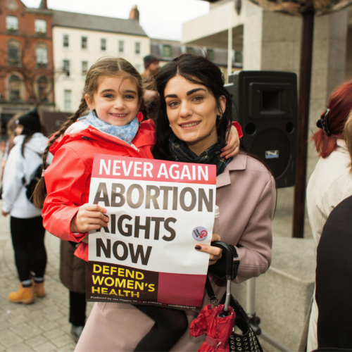 Mom and daughter hold pro-choice poster. Learn how to talk about abortion with Britt Hawthorne