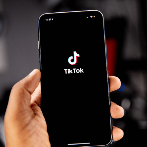 Person holding an iPhone with the TikTok app open. Discover 5 Gen Z activists with Britt Hawthorne. Photo: Solen Feyissa.